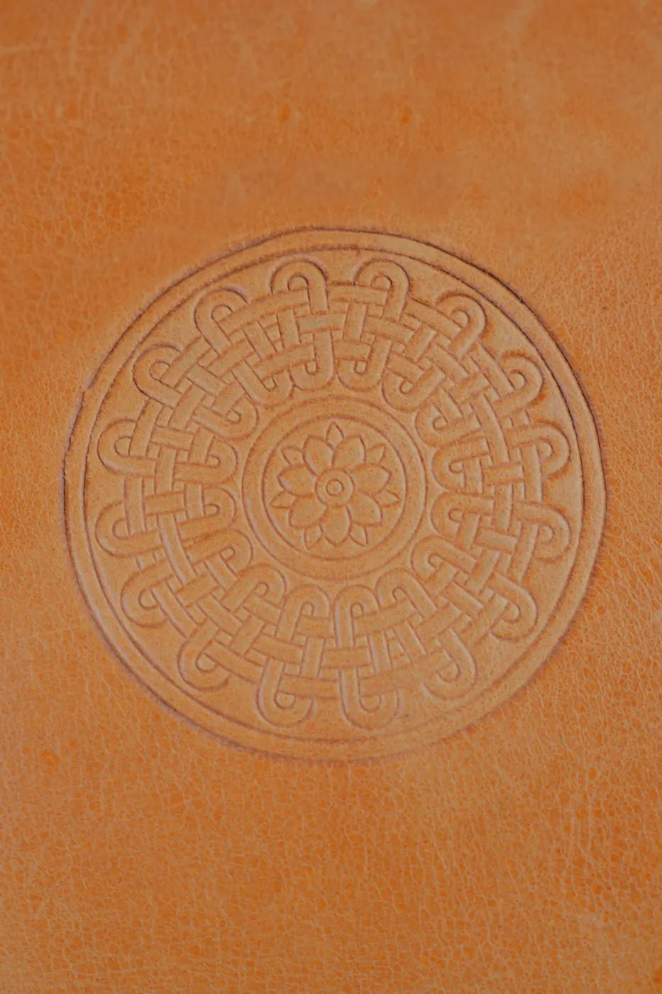 Embossed pattern on a tan leather journal cover
