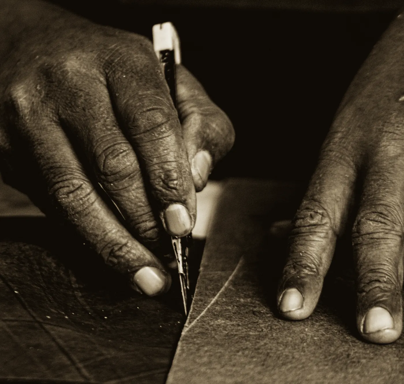 Hands cutting leather in the Felek workshop